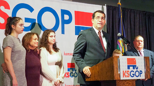Kansas Gov. Laura Kelly leads Republican challenger Derek Schmidt by 14,000 votes Derek Schmidt appears on stage with family