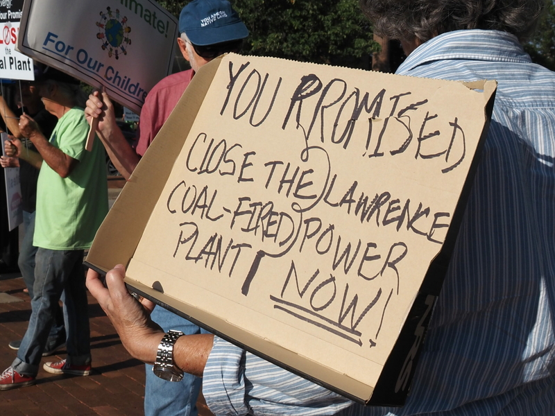 Kansans rally to pressure Evergy into keeping green energy promises Demonstrators hold signs in support of closing the Lawrence coal-fired power plant during a Sept. 13, 2023, rally.